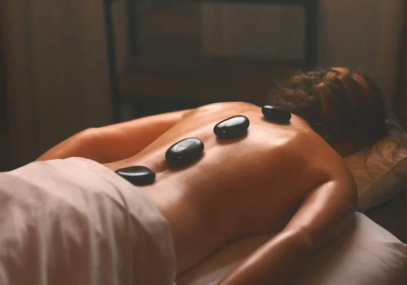 Hot stone massage therapy with volcanic stones on the back